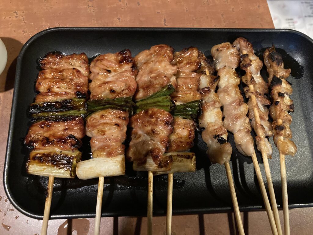 黒い皿に並ぶ焼き鳥の盛り合わせ