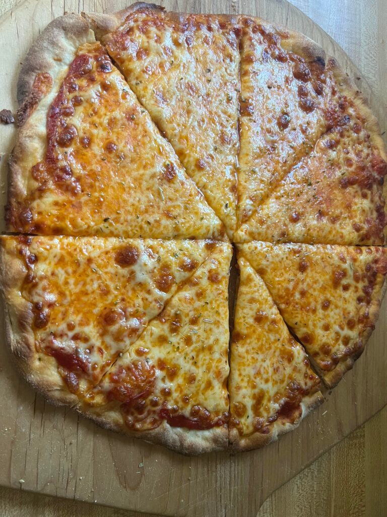 木製の板に乗ったカットされたチーズピザ