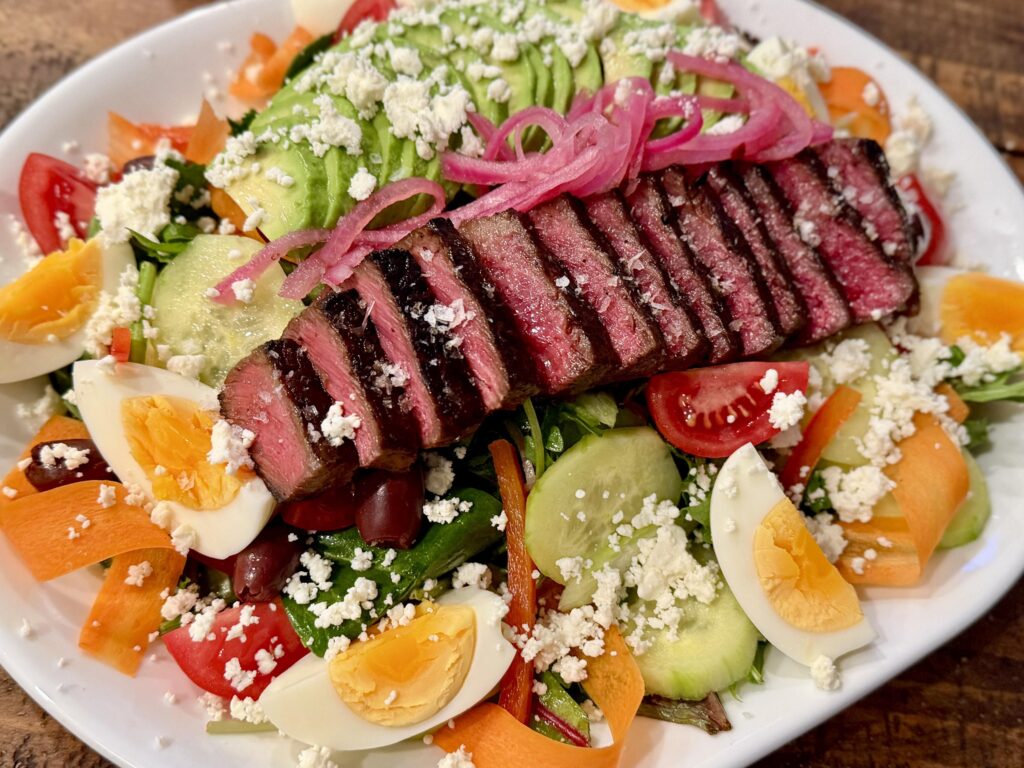 ステーキと卵がのった彩り豊かなサラダ