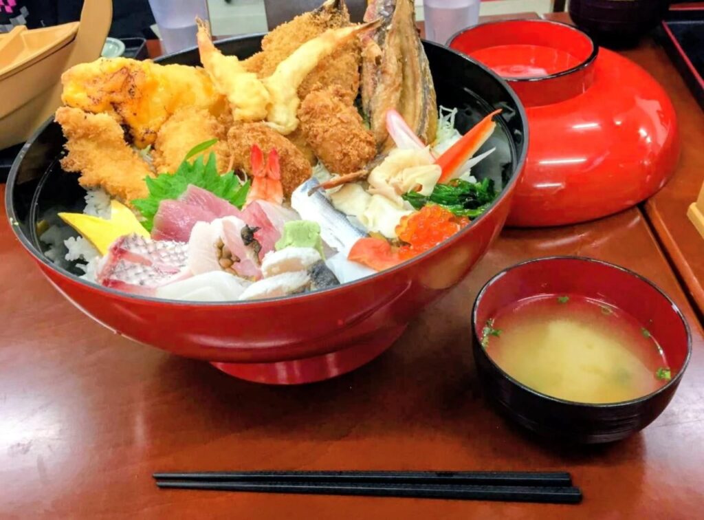 山盛りの天ぷらと刺身の丼ぶりと味噌汁