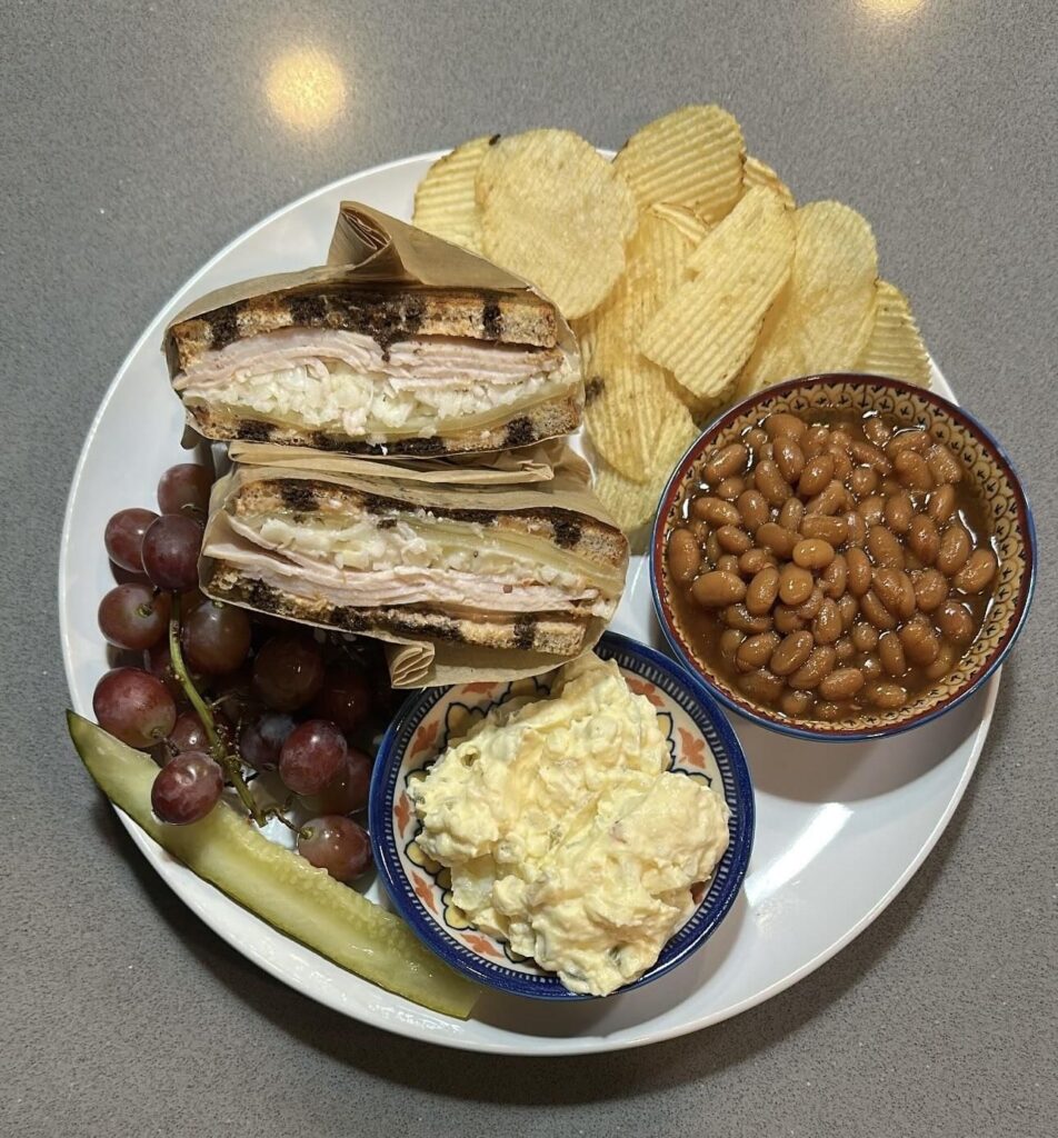 サンドイッチと数種類のサイドが盛られた皿