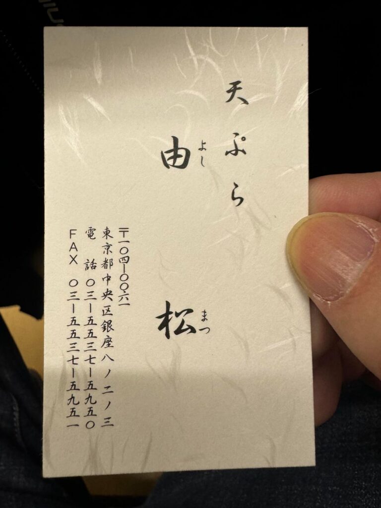 天ぷら屋のショップカードを持つ様子