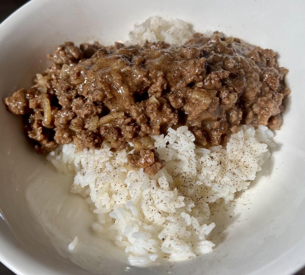 白いボウルに入った白米と挽肉の料理