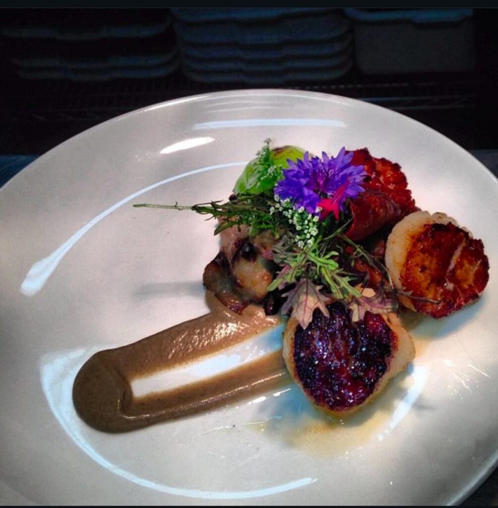 ソースと花が添えられた帆立のソテー