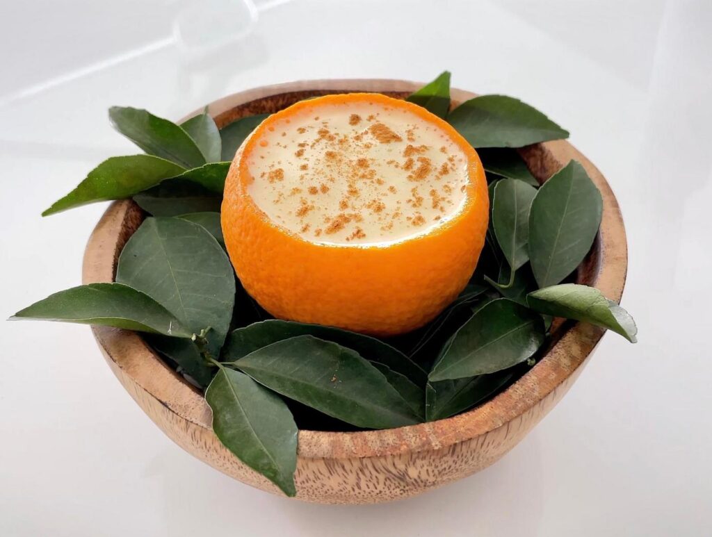 木の器と葉に盛られたオレンジのデザート